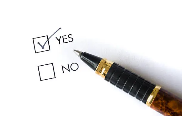 Pen and two boxes for choosing "Yes" or "No. The decision for choicing "YES" has been made by checking the "YES" box. The option may be for a question and answer form, political election, voting on an issue, or consenting to a request.