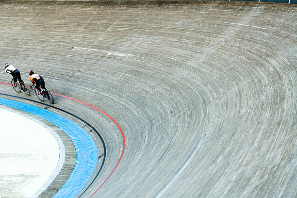 Bicycle Racers Velodrom Speeding bicycle racers flying around curve in bicycle racing velodrome, slight motion blur velodrome stock pictures, royalty-free photos & images