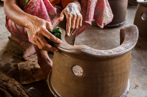 Senior Asian hands polishing a new pottery