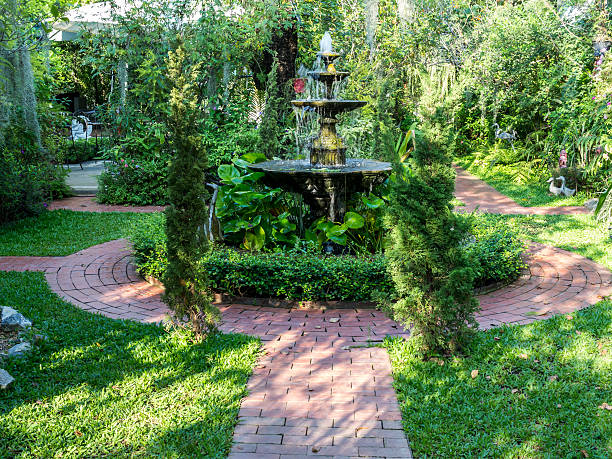 Beautiful summer English formal garden courtyard with fountain ornamental stock photo