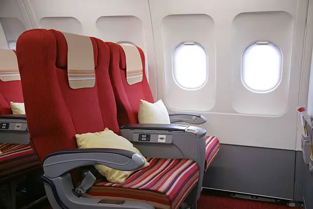 Row of seats on board First Class cabin in aircraft.