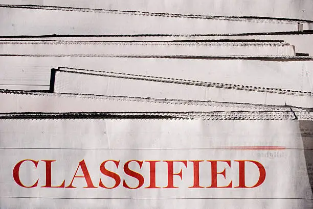 A stack of newspaper with the "Classified" section on top.