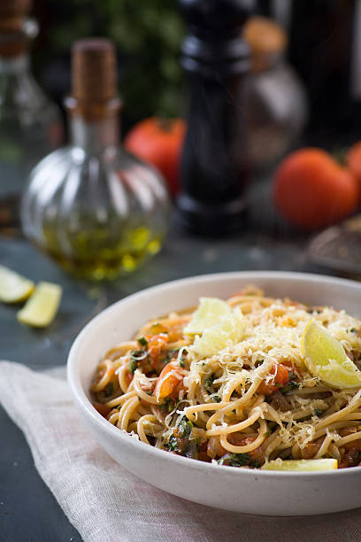 spaghetti with tomato sauce, herbs and lemon stock photo
