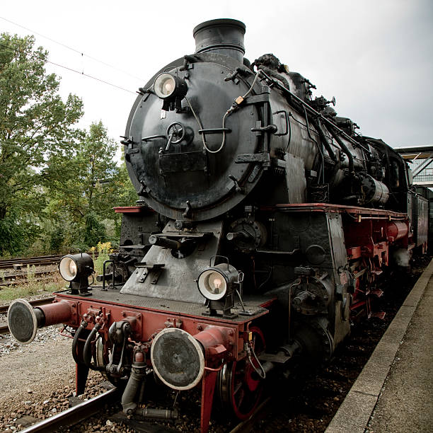 german historic steam locomotive waiting on the rails at the train station.