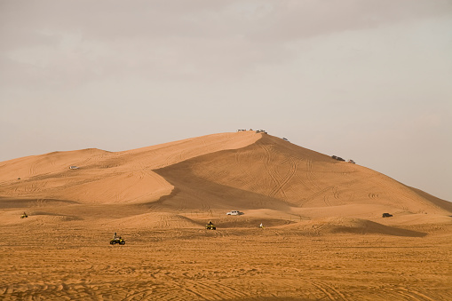 Quadbike and Jeep racing on desert dunes in the United Arab Emirates Desert Dunes.