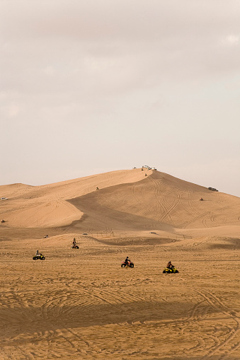 Quadbikes and Jeeps racing on desert dunes in the United Arab Emirates Desert Dunes.