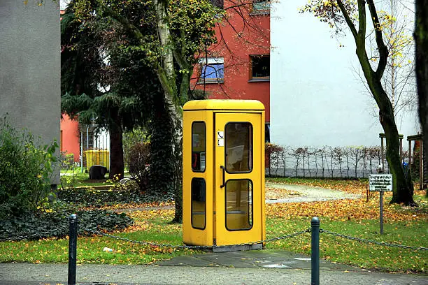 a traditional German phone box in urban setting - sign on lawn states: "private property - no trespassing and not dogs allowed" 