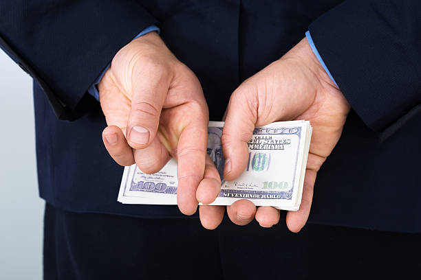 istock Businessman With Finger Crossed Holding Banknotes 471065514