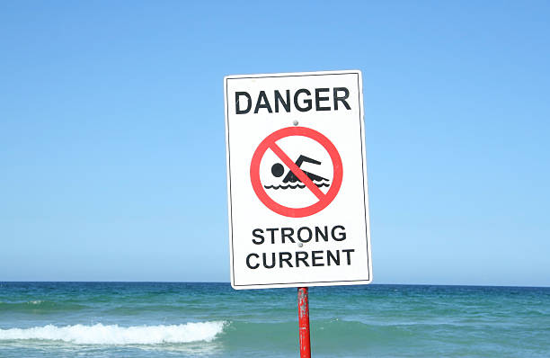 Warning Sign at the Beach Warning Sign "Danger Strong Current" at the beach.  tide going out stock pictures, royalty-free photos & images