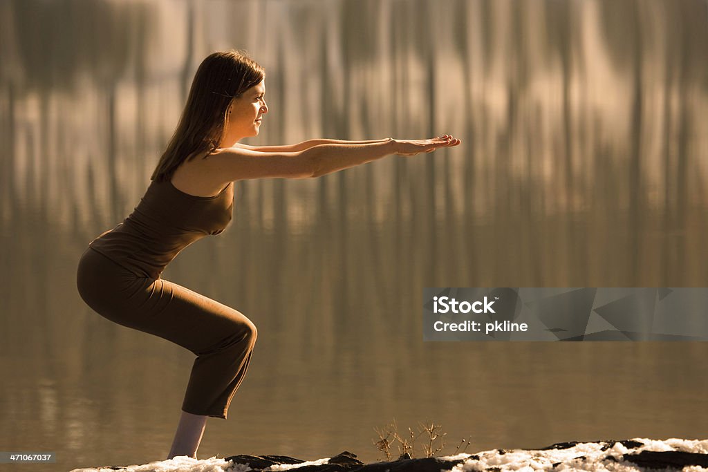 Frau macht Yoga "Stuhl Pose" Neben einem See - Lizenzfrei Arme hoch Stock-Foto