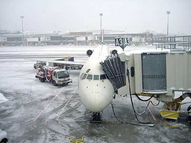 avião no portão em uma tempestade de neve - boston winter snow massachusetts - fotografias e filmes do acervo