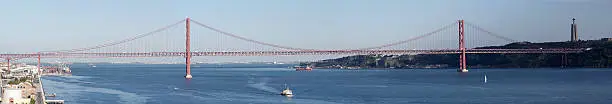 The "25th of April" suspension-bridge in Lisbon which crosses the Tage River. This picture was taken from the top of the famous monument of "Discovery" built just at the shore of the Tage River. In the right of the picture we can see the famous statue of the "Christ-Roi".