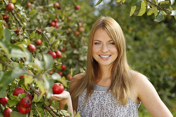 istock Young woman in front of an apple tree 471068906
