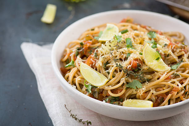 spaghetti with tomato sauce, herbs and lemon stock photo