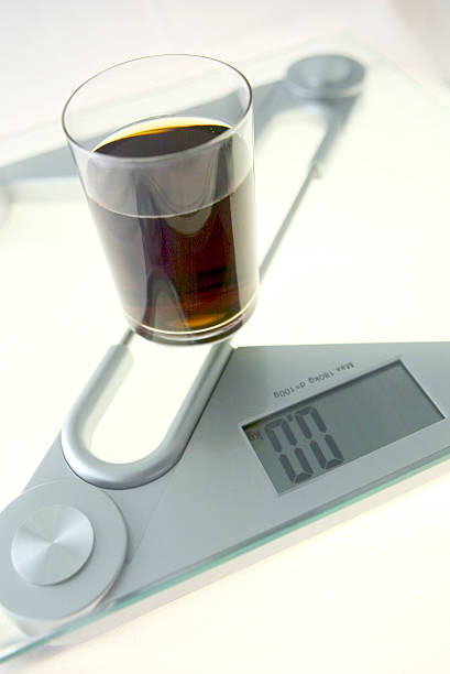 Diet Cola Glass of "diet cola" on the electronic balance showing 0.0kg, methaphore of "cola light" coke zero photos stock pictures, royalty-free photos & images