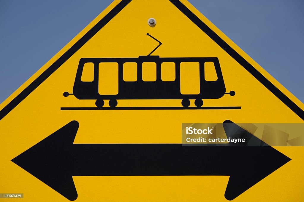 Tram or trolley crossing; look both ways A tram or trolley warning sign provides information to people crossing the street.   Alertness Stock Photo