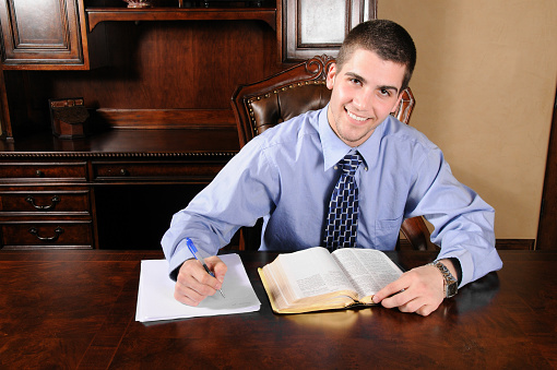 Young man at desk studying his Bible