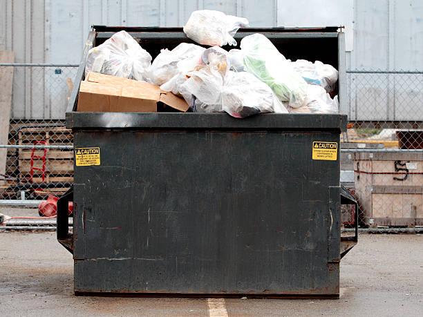 Industrial Garbage Bin Garbage bin full of garbage on a rainy day overflowing dumpster stock pictures, royalty-free photos & images