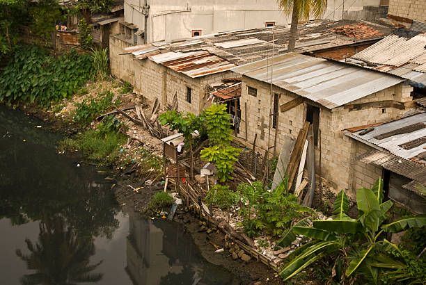 istock Shanty homes by polluted water. 471072453