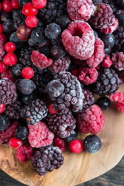 istock mixed frozen berries on wooden background 471072580