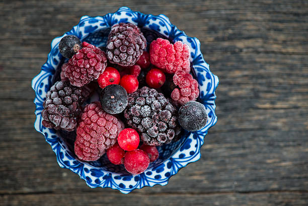 istock mixed frozen berries on wooden background 471072586