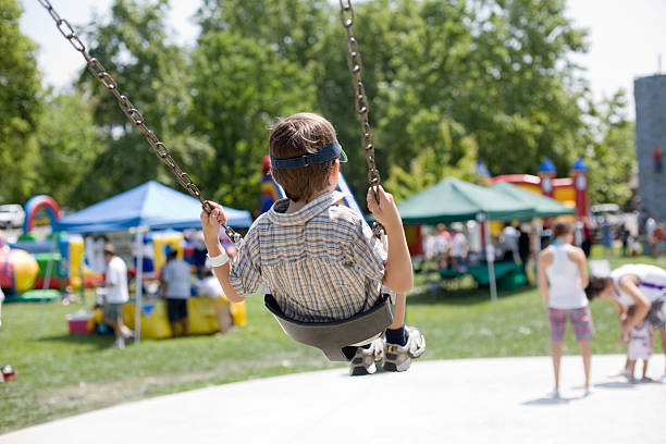 Swinging In A Park Boy on swings. mm1 stock pictures, royalty-free photos & images