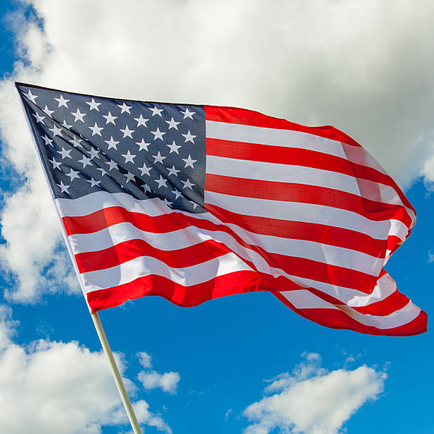 istock Neat USA flag and cumulus clouds behind it 471074038