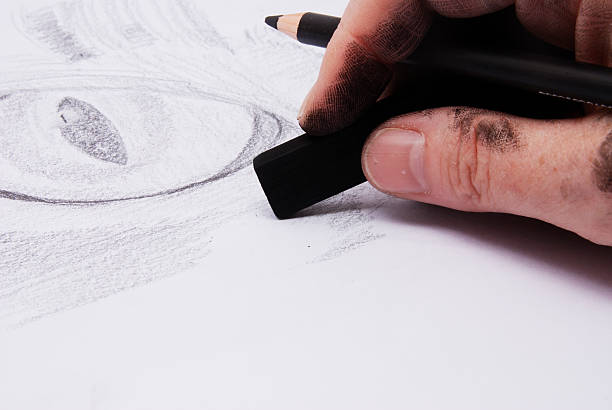 istock Artist using charcoals drawing a cat's eye. 471075109