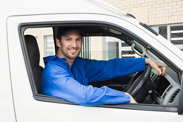 istock Delivery driver smiling at camera in his van 471075780