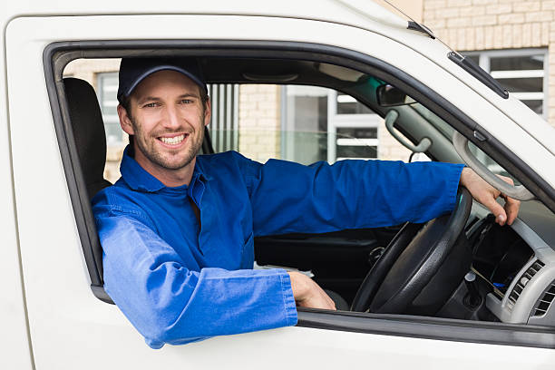istock Delivery driver smiling at camera in his van 471075956