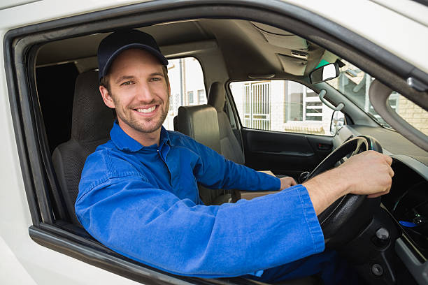istock Delivery driver smiling at camera in his van 471075978