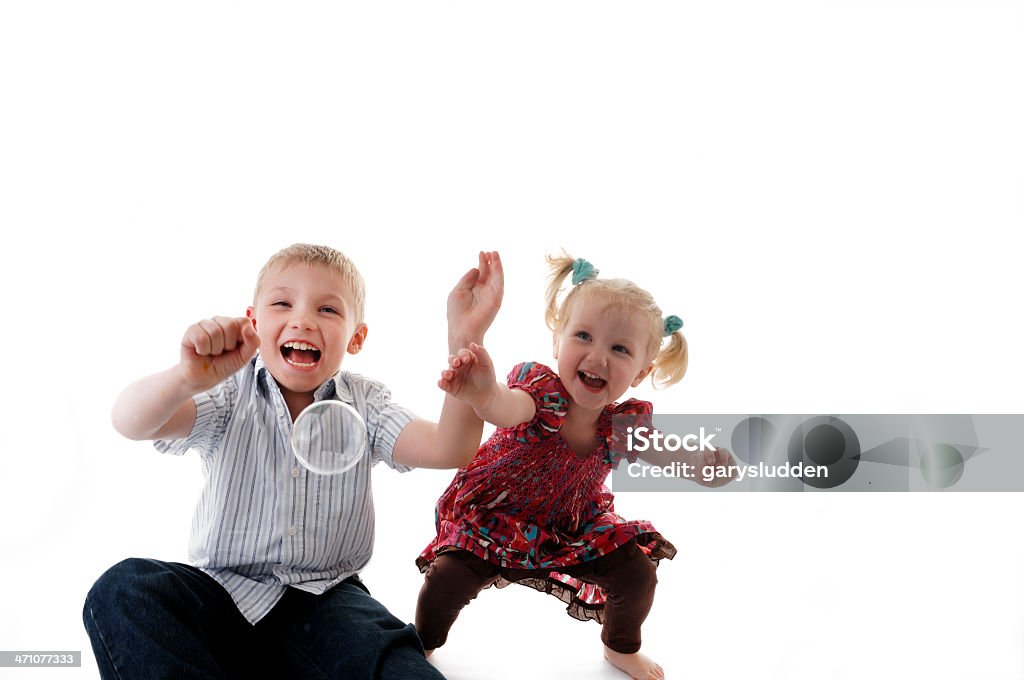 Hermano y hermana jugando con burbujas - Foto de stock de Burbuja libre de derechos