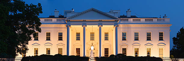 A photograph of the White House at night The White House at night (Washington DC). white house exterior stock pictures, royalty-free photos & images