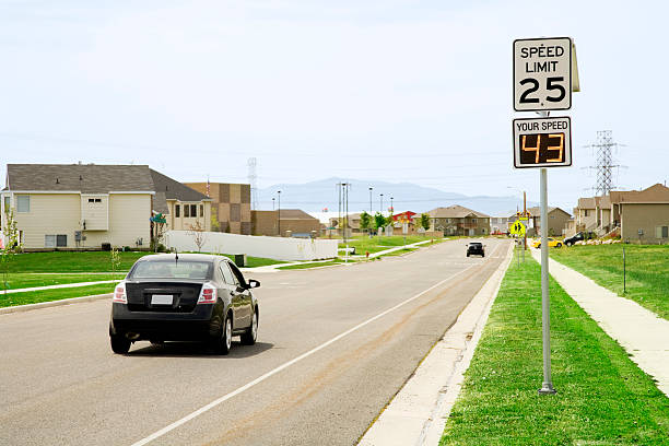 Speeding Motorist Photo of a motorist speeding in a residential school zone.  speed limit sign stock pictures, royalty-free photos & images