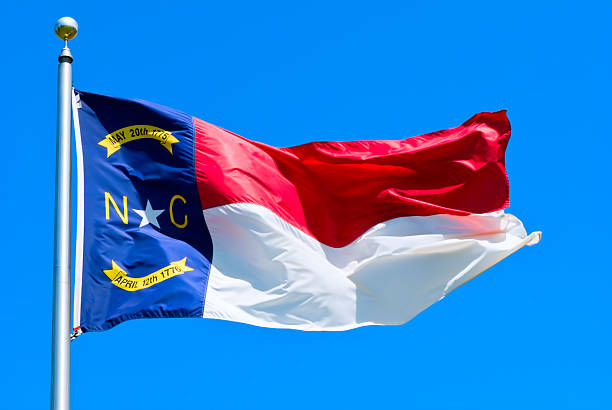 Close-up of a North Carolina flag that is flying in the air North Carolina flag flying in the wind chapel hill photos stock pictures, royalty-free photos & images