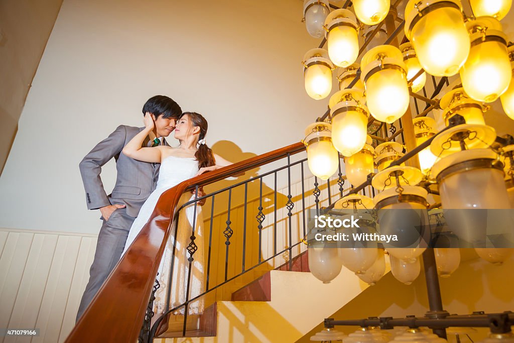 Beautiful asian young bride and groom kissing Beautiful asian young bride and groom kissing on stairs 2015 Stock Photo