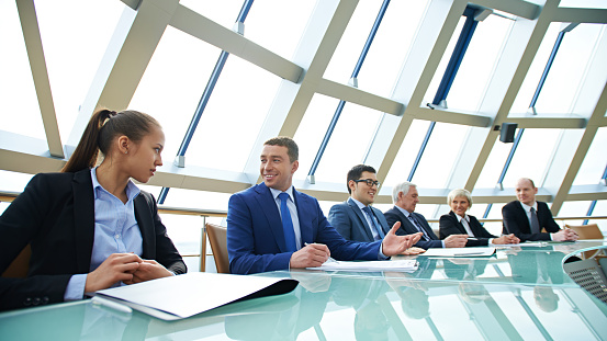 Group of business people sitting at conference table at meeting