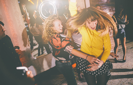 Female friends dancing wildly on the dance floor at a night club