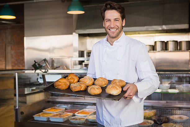 istock Portrait of smiling baker holding tray with bread 471081014