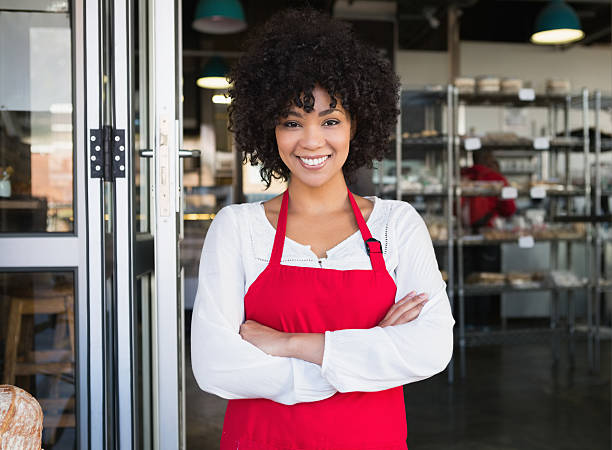 istock Pretty server in red apron with arms crossed 471081090