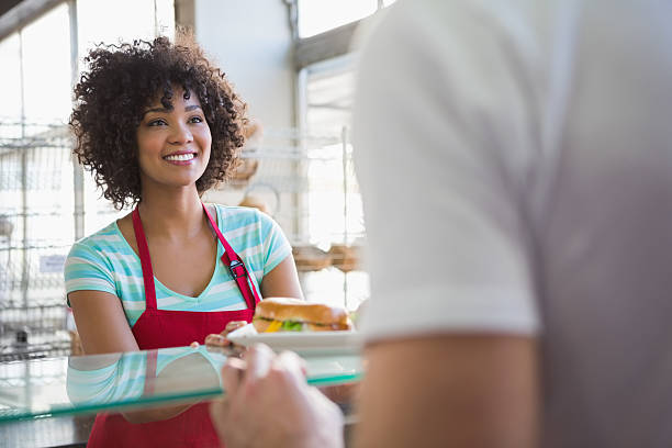 istock Pretty waitress giving sandwich to customer 471083246