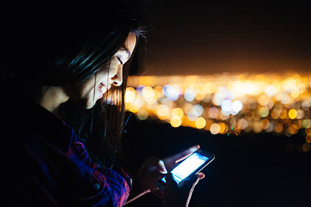istock Young woman on the phone outdoors at night 471084284
