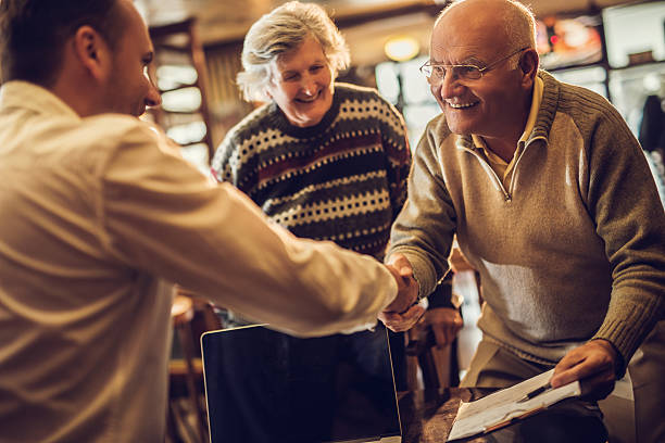 istock Happy old people come to an agreement with insurance agent. 471084606