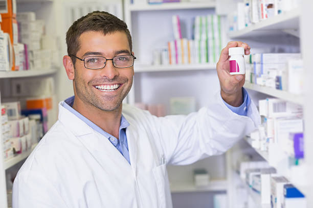 istock Handsome pharmacist holding medicine jar 471084608