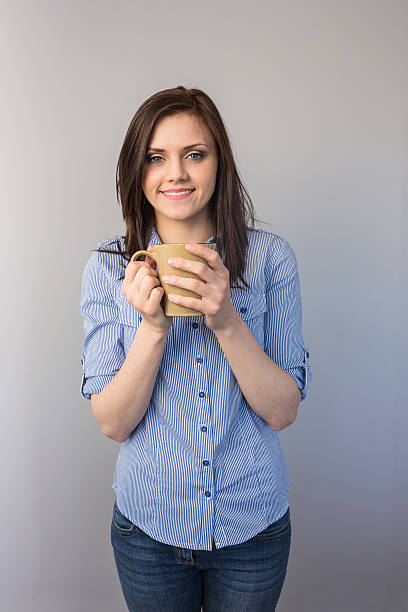 Cheerful pretty brunette holding cup of coffee
