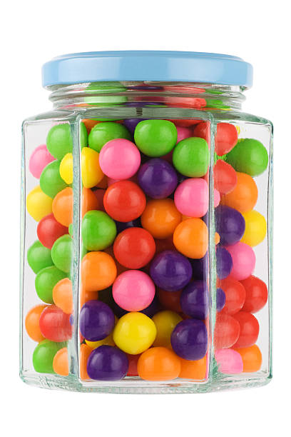 Colorful chewing gums in a hexgonal glass jar. Isolated on pure white.