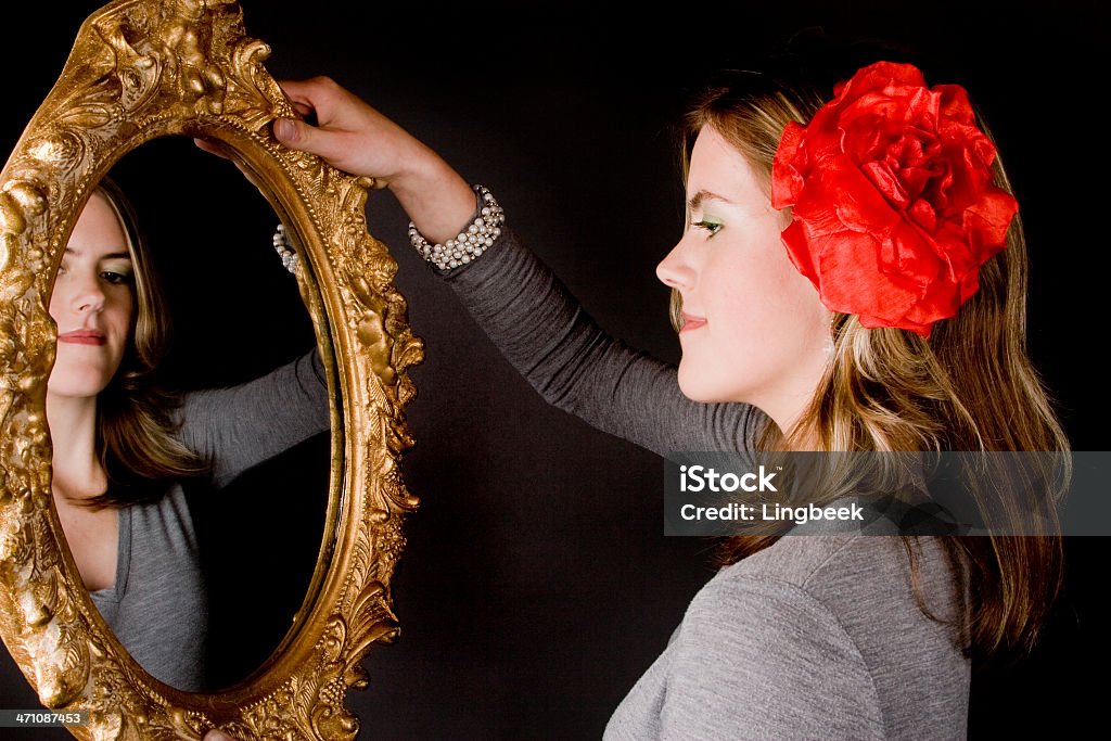 Mujer joven mirando en el espejo - Foto de stock de 18-19 años libre de derechos