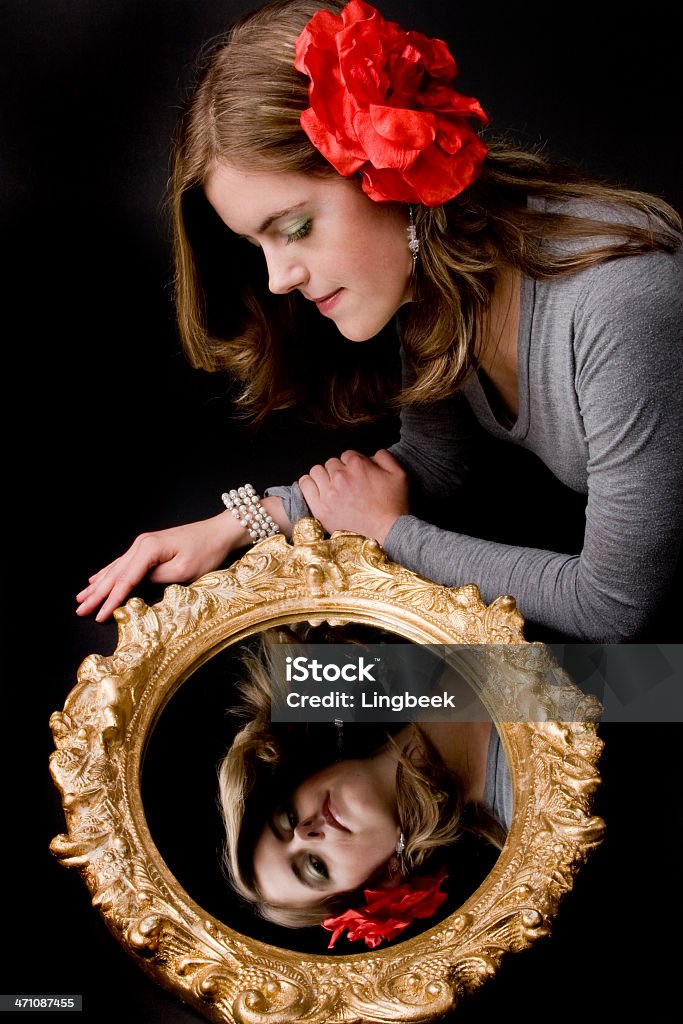 Mujer joven mirando en el espejo - Foto de stock de 18-19 años libre de derechos