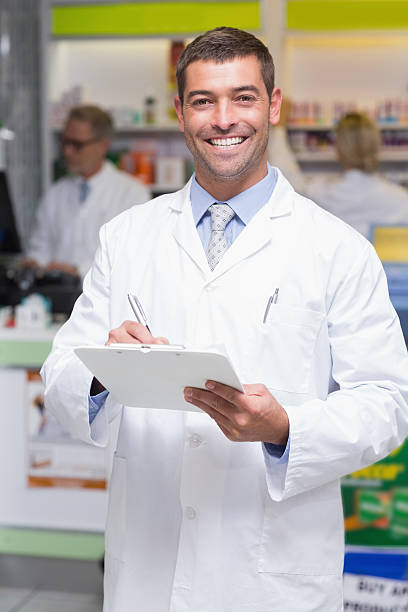 istock Happy pharmacist writing on clipboard 471088394