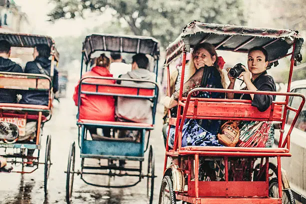 Two photographers enjoying a rickshaw ride in Old Delhi, India.